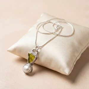 Handmade Cornish sea glass and pearl necklace with yellow-green sea glass and a freshwater pearl in a silver setting.