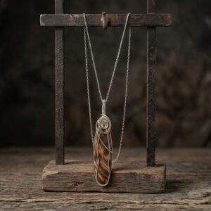 Long oval petrified wood necklace set in silver wire on an 18-inch chain.