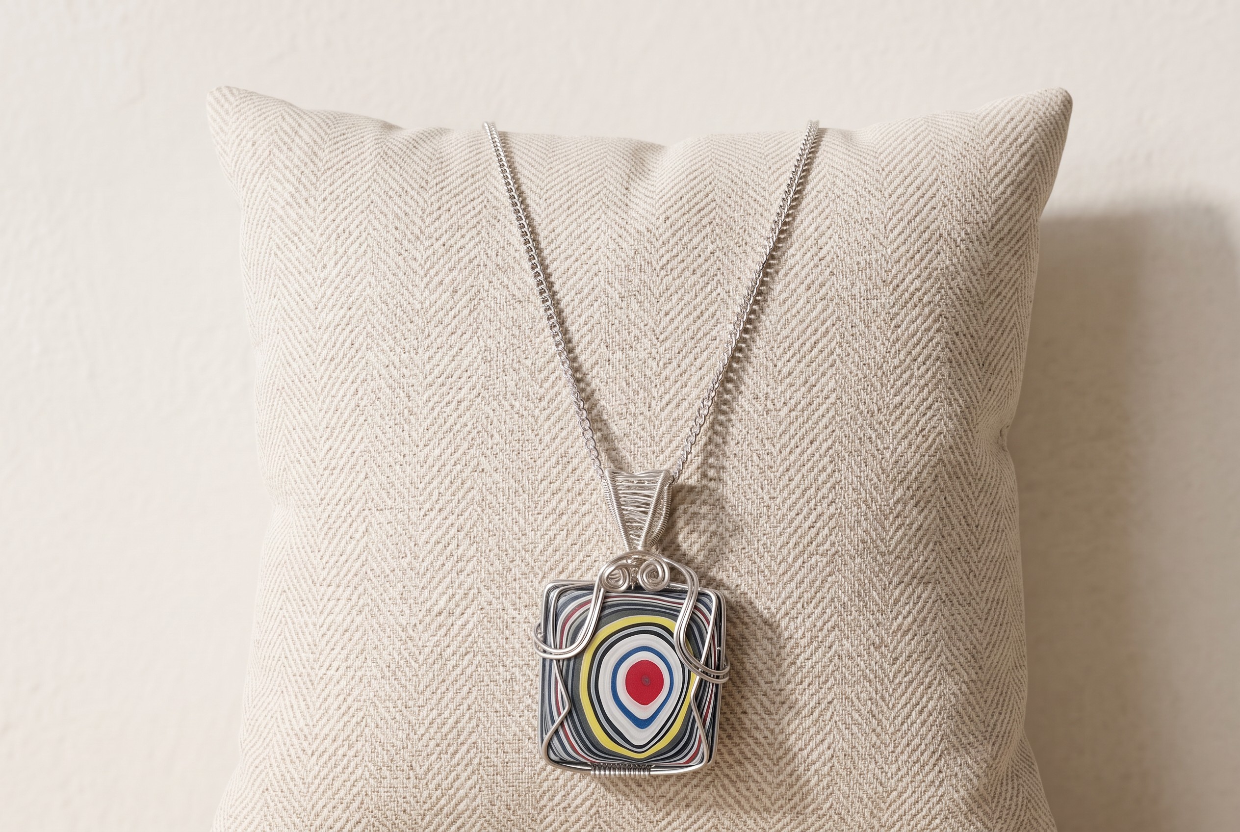 Square genuine Fordite pendant with colourful layered automotive paint, wrapped in silver-plated wire and supplied with a 20-inch chain.