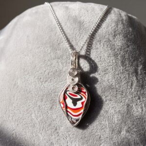 Genuine Fordite teardrop pendant with layered automotive paint patterns, wrapped in silver-plated wire and supplied with a 20-inch chain.FORDITE DETROIT AGATE