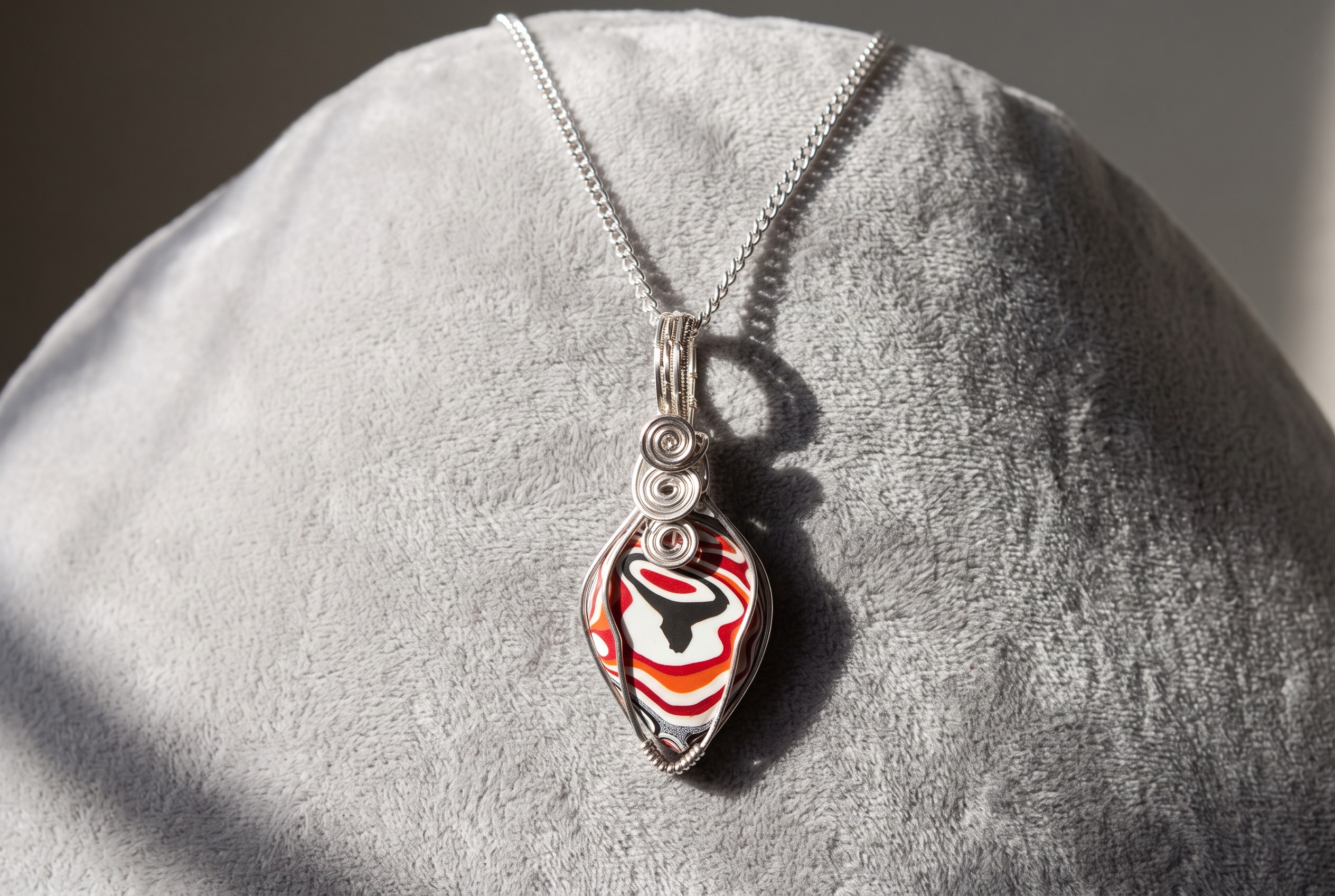 Genuine Fordite teardrop pendant with layered automotive paint patterns, wrapped in silver-plated wire and supplied with a 20-inch chain.FORDITE DETROIT AGATE